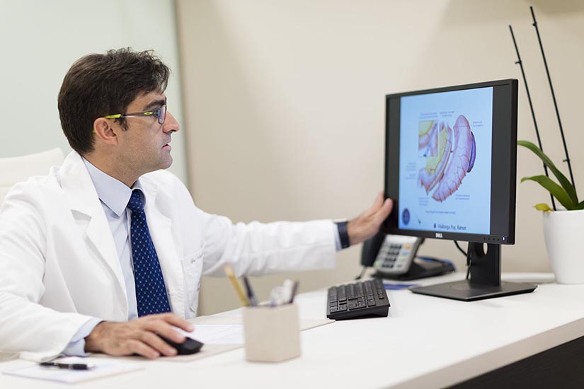 Dr.Ramón Vilallonga Puy mirando por el monitor y resolviendo las dudas sobre la cirugía de la obesidad